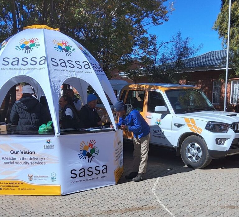 SASSA representative helping new applicant with a registration form at service booth, SASSA Opened New Grant Applications for June 2025